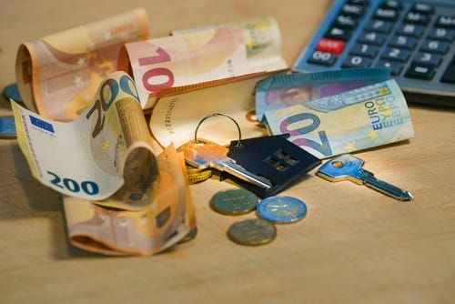 banknotes-and-keys-on-wooden-surface