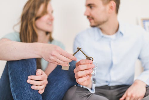 man-and-woman-sitting-while-holding-keys
